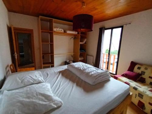 a bedroom with a bed and a large window at Maison familiale 8 personnes au coeur de Loudenvielle in Loudenvielle
