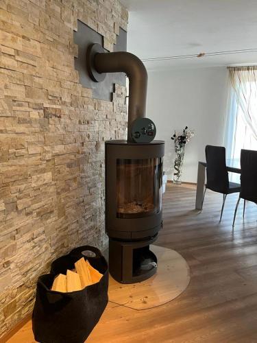 a fireplace in a living room with a brick wall at CA' del GIACOMINO in Baselga di Pinè
