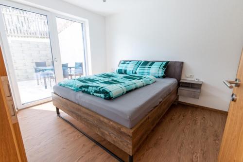 a bed in a room with a large window at Ferienwohnung Pedit in Tarrenz