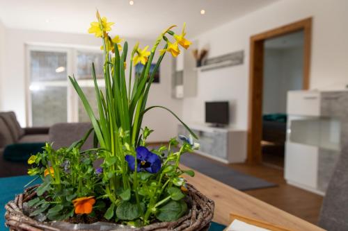 a basket with flowers on a table in a living room at Ferienwohnung Pedit in Tarrenz