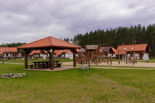 a park with a picnic table and a pavilion at Rozmaryn - Komfortowy domek całoroczny na Kaszubach in Borowy Młyn