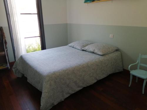 une chambre avec un lit, une chaise et une fenêtre dans l'établissement Villa familiale à la campagne avec vue sur le fleuve - proche de Bordeaux, à Bourg