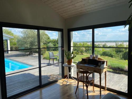 un bureau avec un bureau et une vue sur la piscine dans l'établissement Villa familiale à la campagne avec vue sur le fleuve - proche de Bordeaux, à Bourg