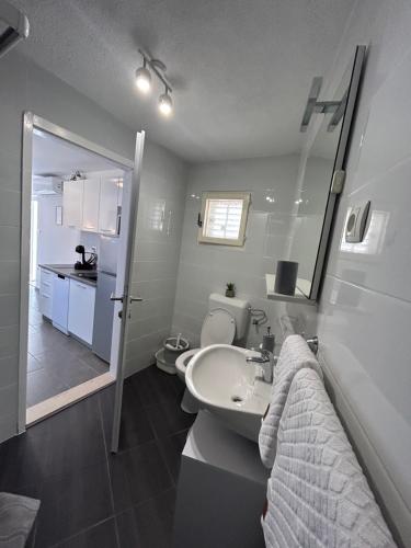 a white bathroom with a sink and a toilet at Little Shine in Bol