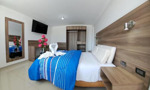 a bedroom with a blue and white bed and a table at Hoteles Gutiérrez Mansión in Arequipa