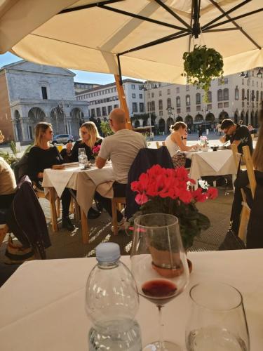 un gruppo di persone seduti a un tavolo con bicchieri da vino di Bright and Large Apartment Via Montegrappa a Livorno