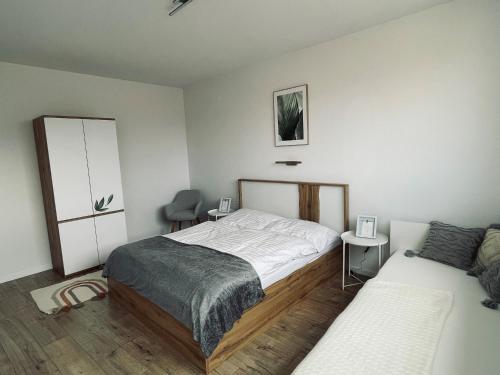 ein Schlafzimmer mit einem Bett und einem Stuhl darin in der Unterkunft Apartmány 400 in Veľká Lomnica
