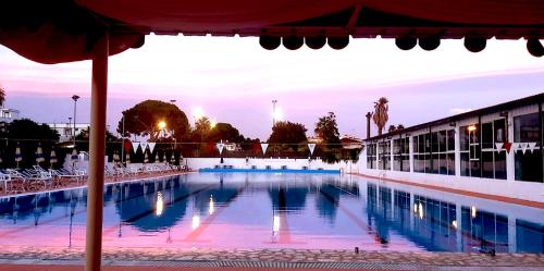 una gran piscina con sillas y sombrilla en Casa vacanze La Marinella, en SantʼEufemia Lamezia