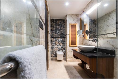 een badkamer met een wastafel en een glazen douche bij The Gawaling ladakh in Leh