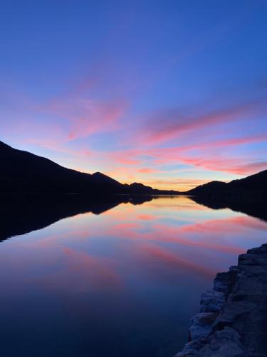 vista para um lago ao pôr-do-sol em Hotel Seerose em Fuschl am See