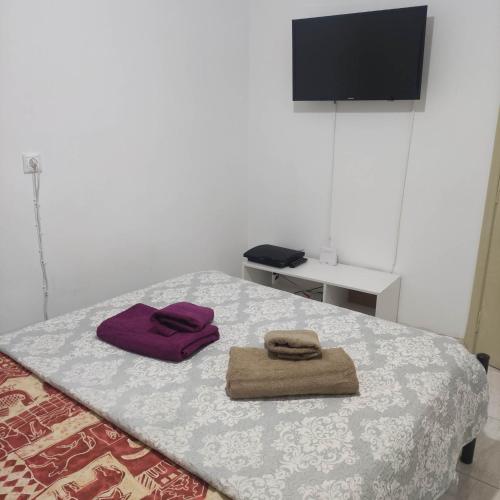 een slaapkamer met een bed met twee handdoeken erop bij SMALL AND COMFORTABLE APARTMENT VATHI SAMOS in Vathý