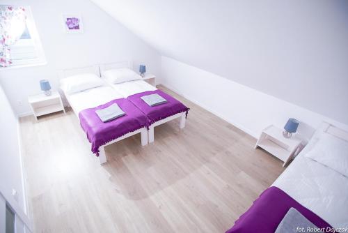 a white room with a bed with purple sheets at Baltic Stone in Rewal