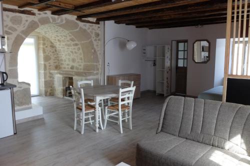 a living room with a table and chairs and a couch at Le Cosy in Sousceyrac