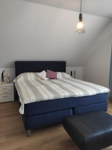 Un dormitorio con una cama azul con un taburete azul en Ferienwohnung Unter dem Sonnberg en Auggen