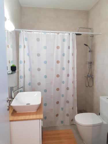 a bathroom with a sink and a shower curtain at Sea Breeze Apartment in Ixia