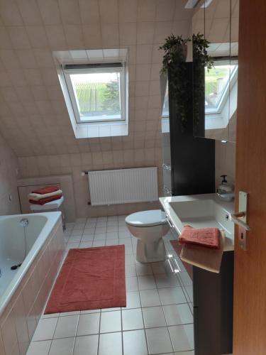 a bathroom with a tub and a toilet and a sink at Ferienwohnung Unter dem Sonnberg in Auggen