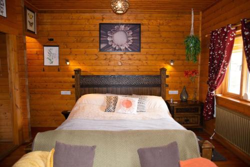 a bedroom with a bed in a log cabin at APPLE Cabin - Little Log Cabin in Wales in Newtown
