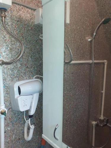 a shower stall with a blow dryer and a shower at Kućice Paradiso in Bratunac