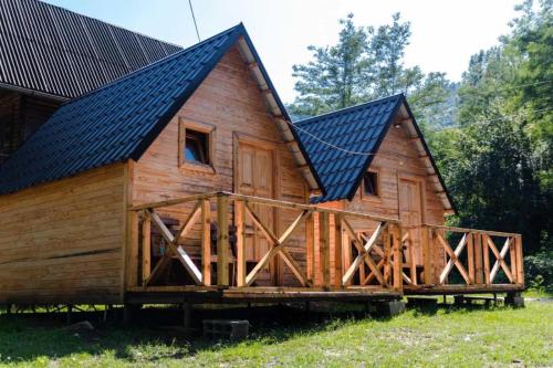une grande cabane en bois avec un toit noir dans l'établissement Kućice Paradiso, à Bratunac