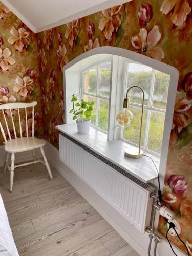 a room with a window and a table with a chair at Charmigt sekelskifteshus med närhet till det mesta in Eskilstuna