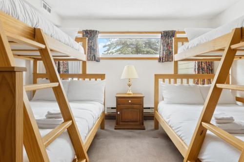 two bunk beds in a room with a window at Blue Mountain Ski In Ski Out Resort Condo 2 Level in Blue Mountains