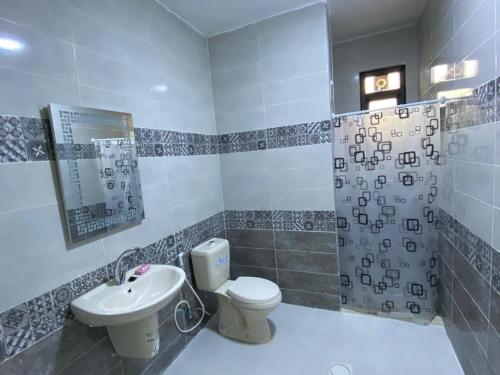 łazienka z toaletą i umywalką w obiekcie Moon Apartments w mieście Dżarasz