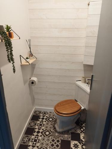 une salle de bain avec toilettes avec un siège de toilette en bois dans l'établissement Maison de village avec vue sur les montagnes, à Bigorno