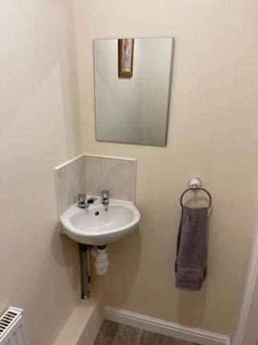 a bathroom with a sink and a mirror on the wall at Spacious 8 bed house in central Grimsby in Grimsby