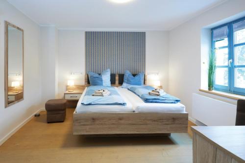 a bedroom with a large bed with blue pillows at Pension "Zum Reußischen Hof" in Thallwitz