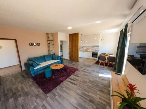 un soggiorno con divano blu e tavolo di Apartman KOSTA a Trebinje