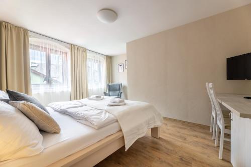 a bedroom with a bed and a table and a desk at Apartmány U Pavla in Český Krumlov