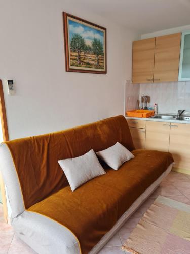 a brown couch with two pillows on it in a kitchen at Apartment Bataja in Brkač