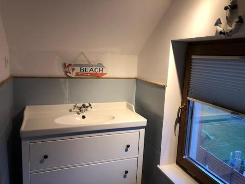 a small bathroom with a sink and a window at Apartament Premium Łeba in Żarnowska