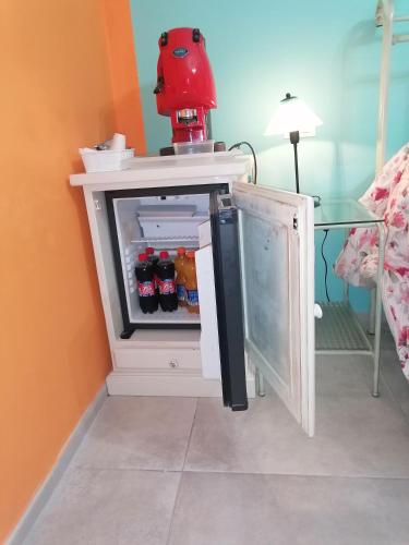 a small refrigerator with a red blender on top of it at affittacamere il sole in Montopoli in Val dʼArno