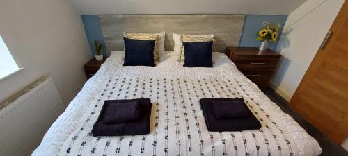 sypialnia z 2 łóżkami i niebieskimi poduszkami w obiekcie The Chapel House w mieście Saint Helens
