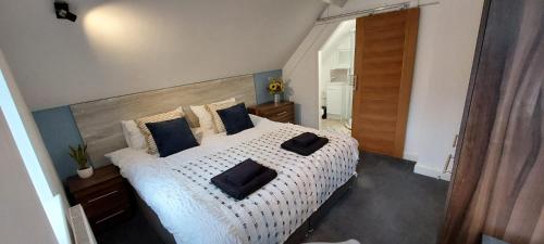 sypialnia z dużym białym łóżkiem z czarnymi poduszkami w obiekcie The Chapel House w mieście Saint Helens