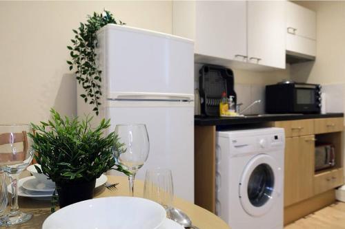 a kitchen with a table with glasses of wine at LFC Stadium Apartment 4 in Liverpool