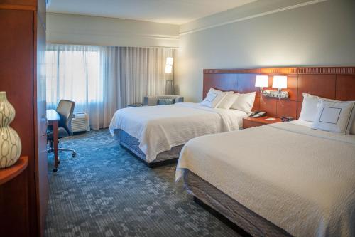 a hotel room with two beds and a window at Courtyard by Marriott Pensacola Downtown in Pensacola