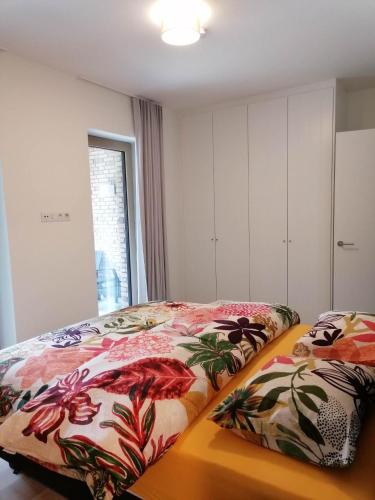 a bedroom with two beds with colorful blankets at Bartine - modern and spacious flat near the sea, free parking space in Ostend