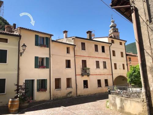 ein altes Gebäude mit einem Turm darüber in der Unterkunft Borgo Ferracina by BORGHI VENETI in Solagna