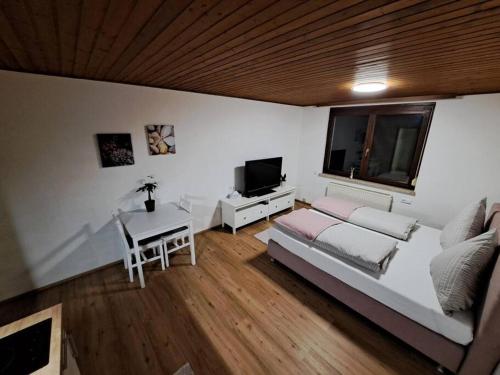 Dormitorio con cama, escritorio y TV en Ferienwohnung Zanier, en Gaißau