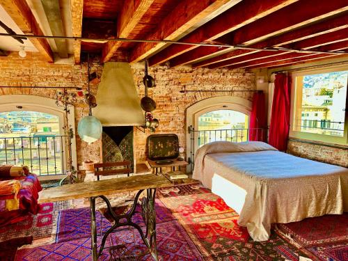 a bedroom with a bed and a stone wall at Torre Ducale Dimora Storica in Genova
