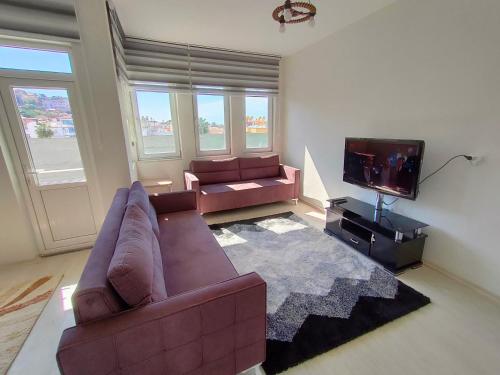 a living room with a couch and a flat screen tv at The Life House Alanya in Alanya