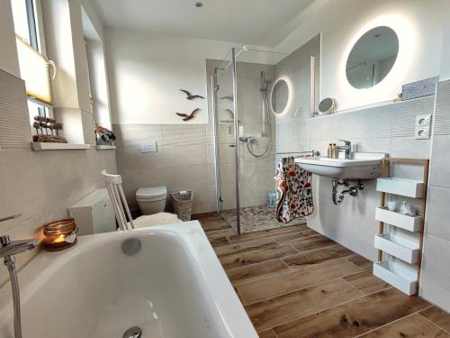 uma casa de banho com uma banheira, um lavatório e um chuveiro em Ferienhaus Zur Oie em Bresewitz