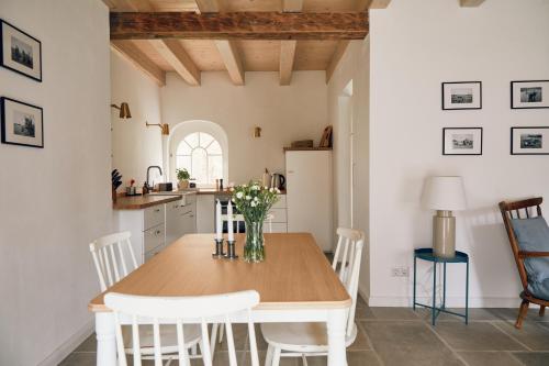 a kitchen and dining room with a wooden table and chairs at Wäscherei in Barkelsby