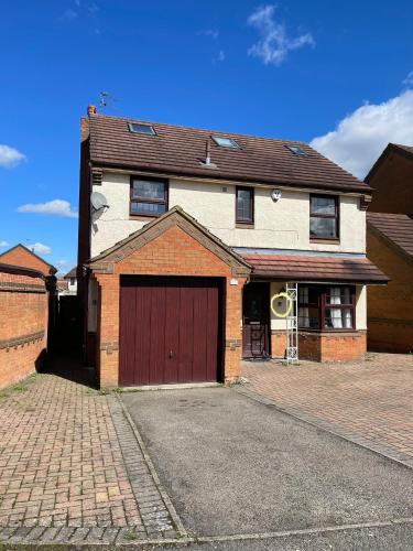 a large brick house with a red garage at Large, 3 Floors, Sleeps 16, 4 Baths, 5 Parking, Semi rural Leicester in Leicester