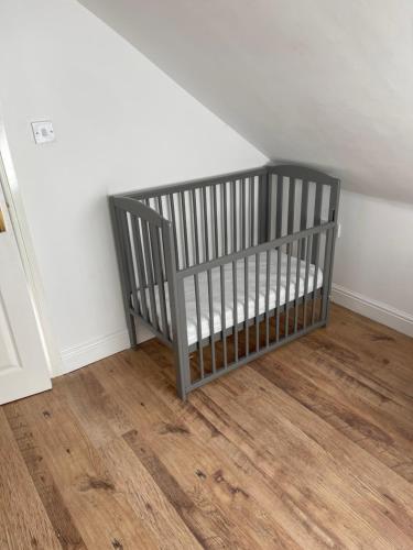 a crib sitting in the corner of a room at Large, 3 Floors, Sleeps 16, 4 Baths, 5 Parking, Semi rural Leicester in Leicester