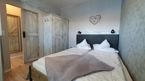 een slaapkamer met een groot wit bed met witte kussens bij Wilhelms Mitte in Wilhelmshaven