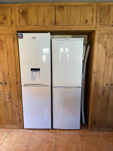 two white refrigerators in a room with wooden cabinets at Large, 3 Floors, Sleeps 16, 4 Baths, 5 Parking, Semi rural Leicester in Leicester