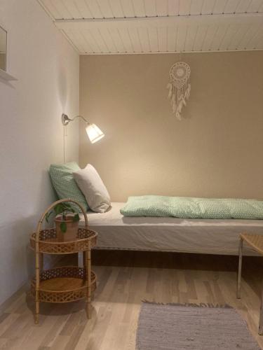 ein Schlafzimmer mit einem Bett, einem Tisch und einem Stuhl in der Unterkunft Skovlyset’s B&B in Juelsminde